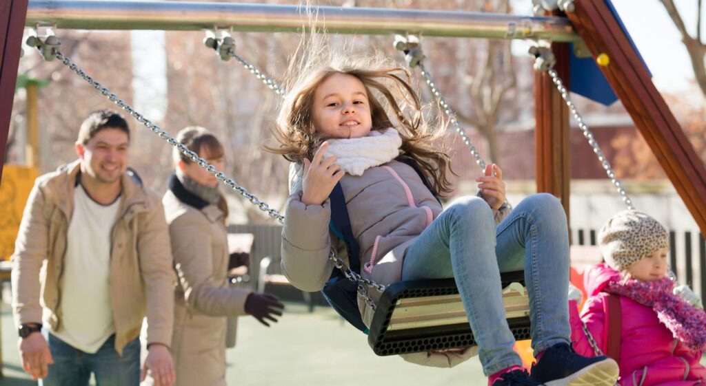 Girl on swing in park during winter