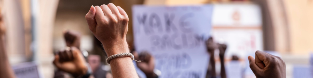 Raised fists and a picket sign at a protest