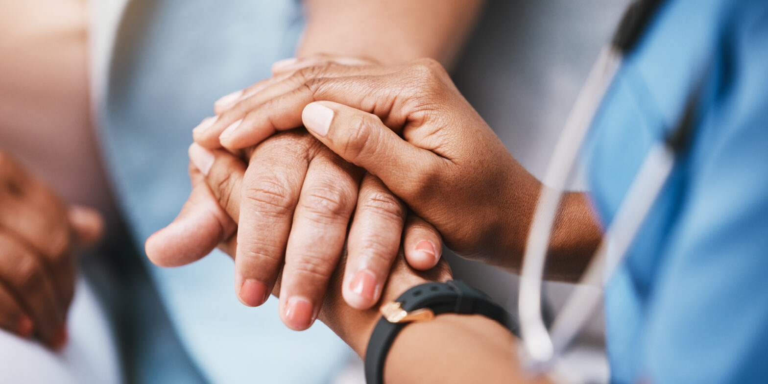 nurse holding patient's hand